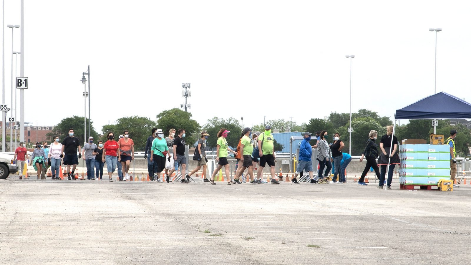 Voluntarios preparando un reparto masivo de alimentos de un banco de comida en un estadio.