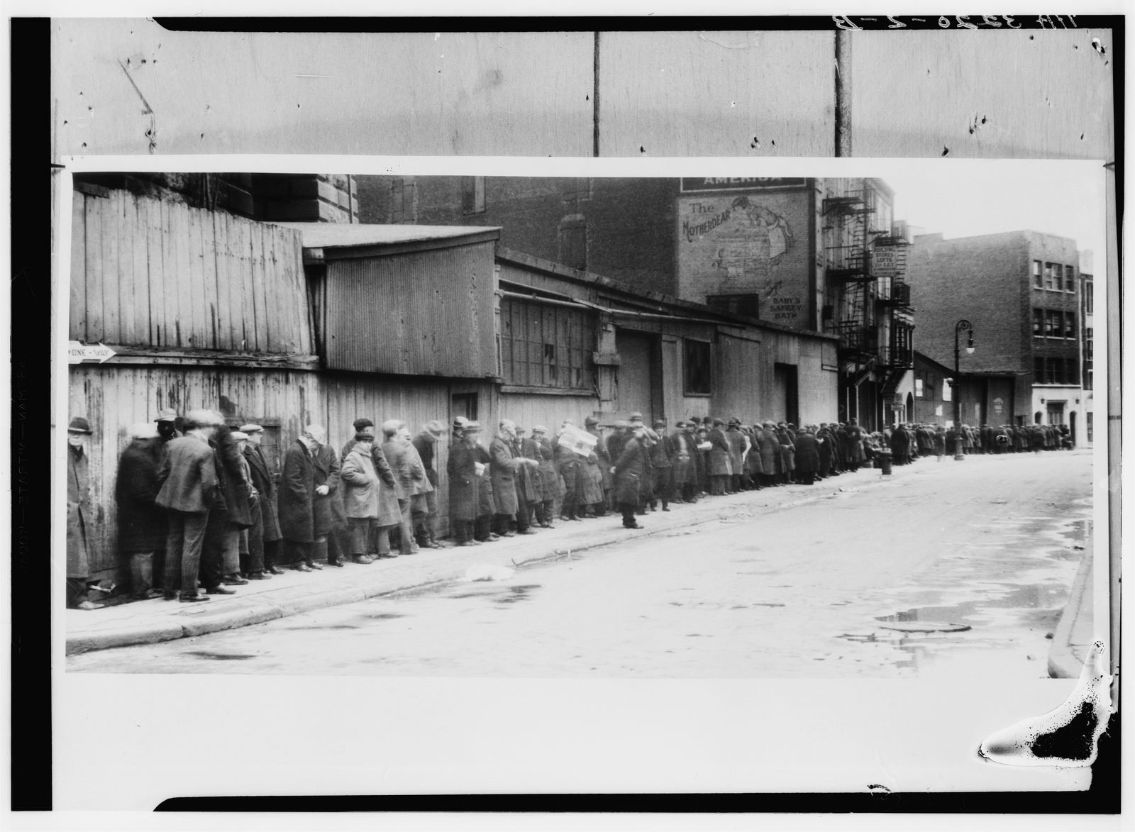 Fila de hombres esperando en un comedor social bajo el puente de Brooklyn durante la Gran Depresión.